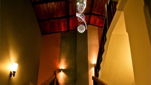 A staircase with wooden railings and a chandelier. - Hotel Travellers Nest (Kandy)