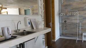 Une cuisine moderne équipée d’un évier, d’une machine à café et d’un porte-serviettes.