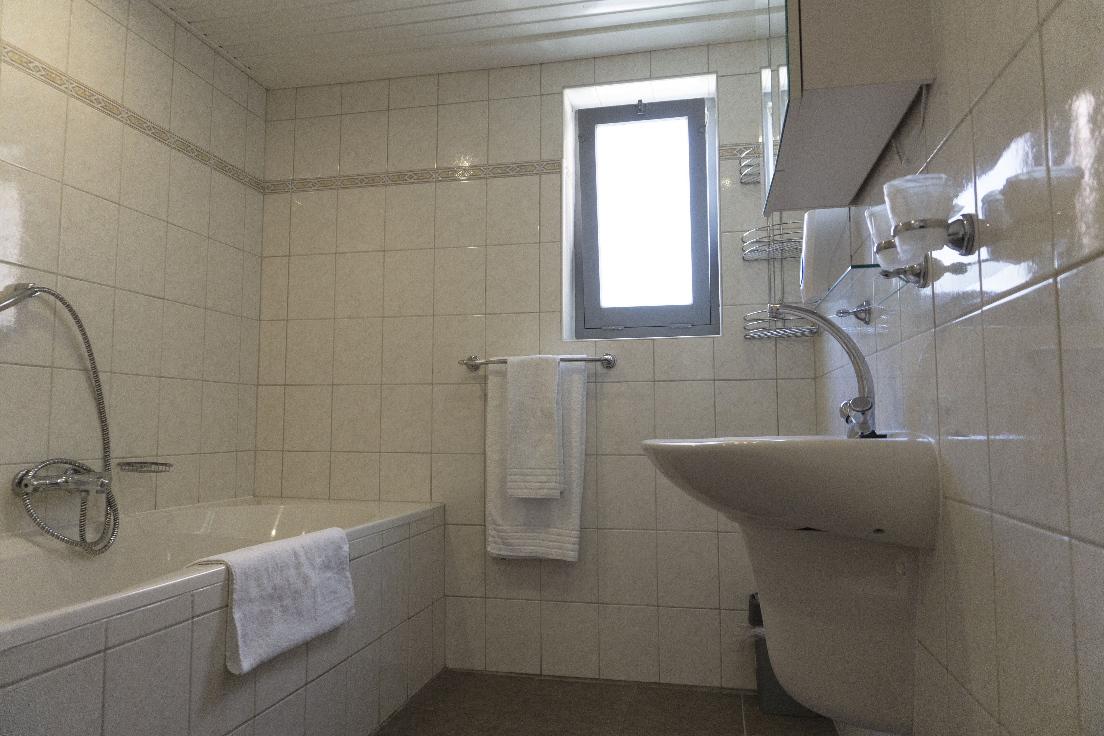 Un baño con bañera, lavamanos y ventana.