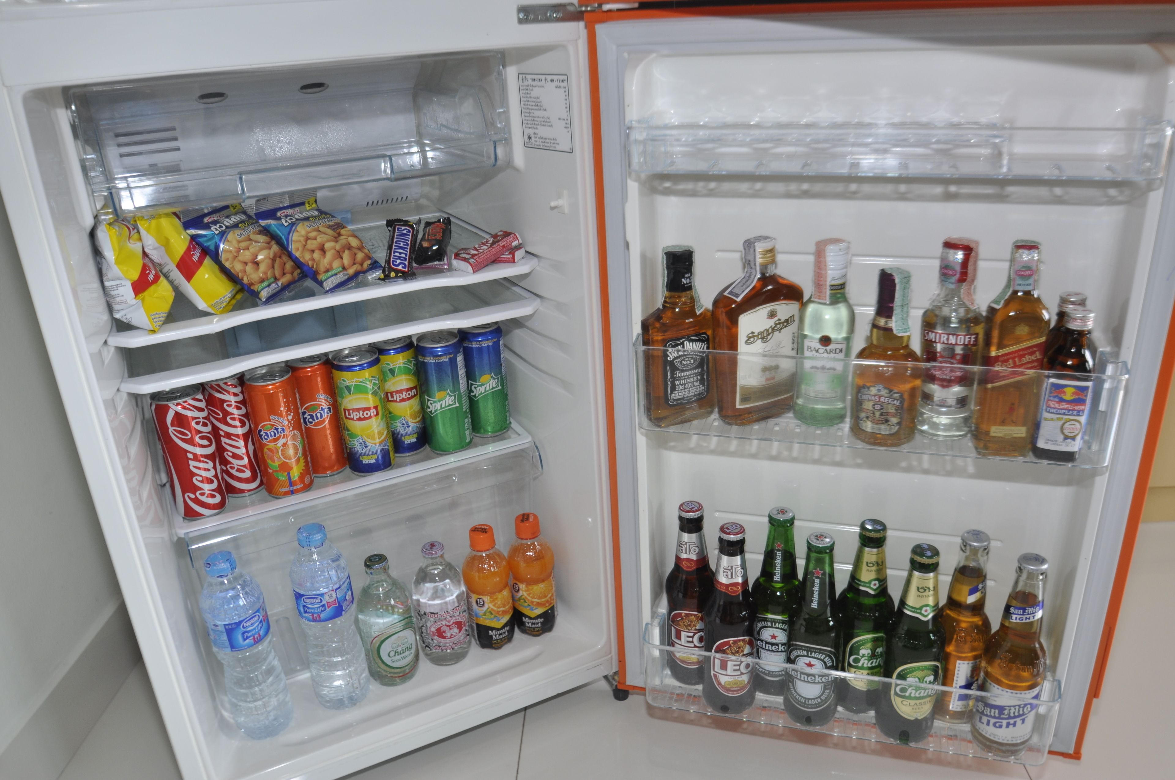 Ein Kühlschrank gefüllt mit Snacks, Getränken und Flaschen.