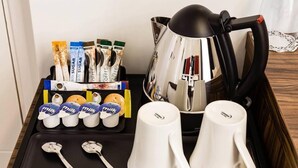 A tray with a coffee maker, milk cartons, and two white mugs. - Metro London City Airport (London)
