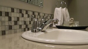 A bathroom sink with a modern faucet and a tiled backsplash. - Metro London City Airport (London)