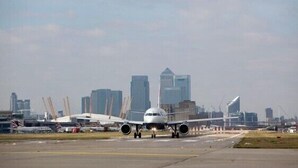 An airplane on the runway with a city skyline in the background. - Metro London City Airport (London)