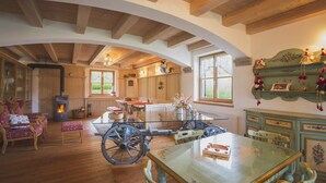 A rustic interior with wooden beams, a large table, and vintage furniture.