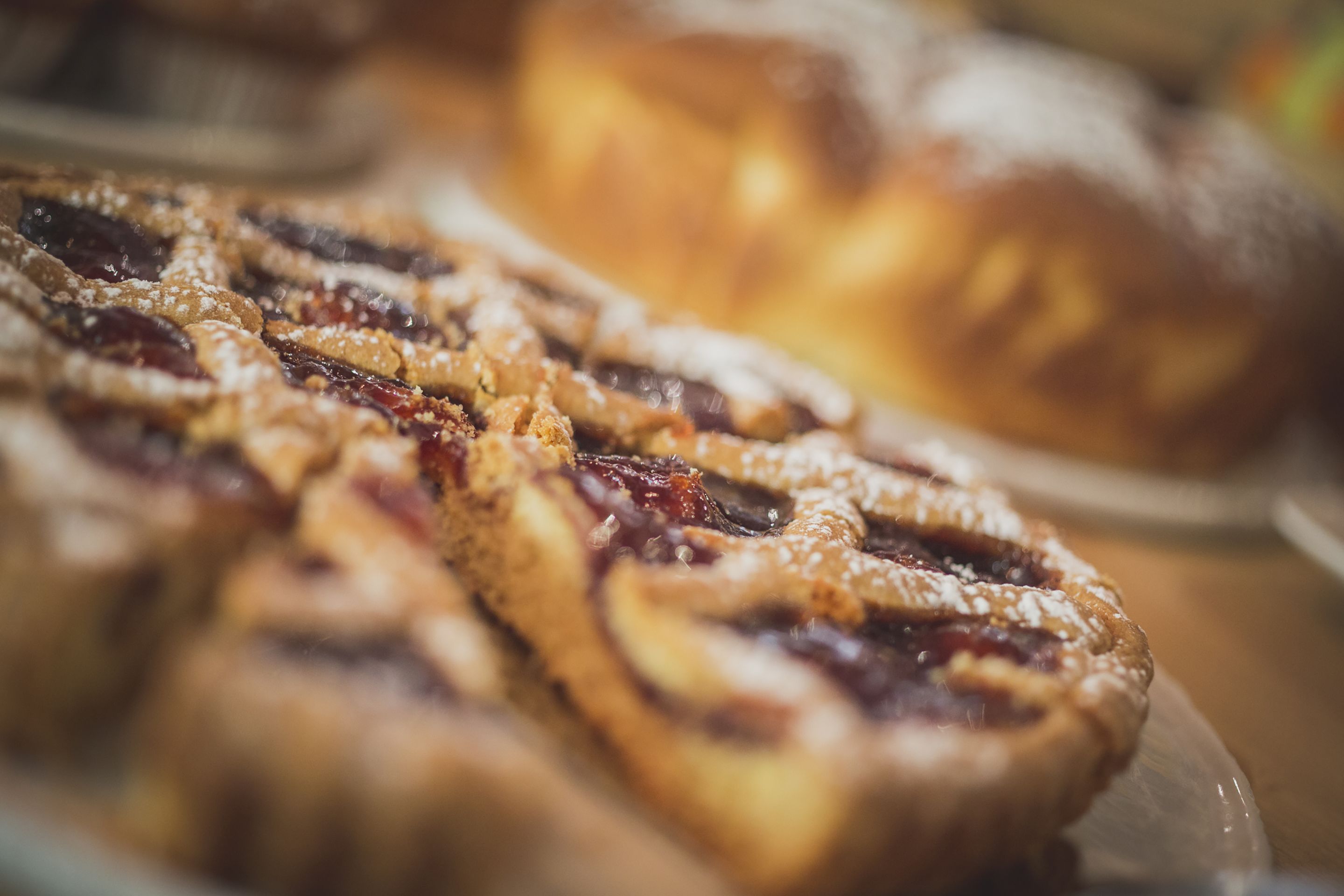 A close-up of pastries with a flaky crust and a filling that appears to be fruit-based, possibly cherry or berry.