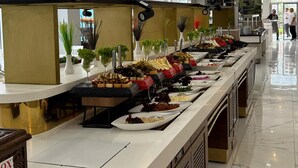 Un bufé con diversos alimentos, un techo blanco y un interior moderno y limpio.