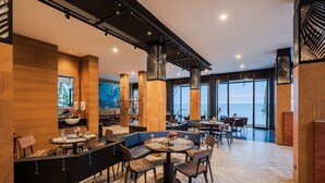 Ein modernes Restaurant mit Holzwänden, großen Fenstern und Meerblick.
