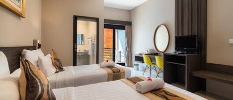 A hotel room with two beds, a desk, a TV, and a balcony with a view.