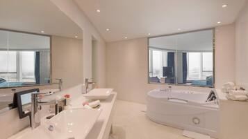 A modern bathroom with two sinks, a large bathtub, and a large mirror.