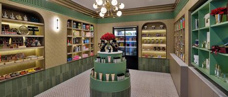 A luxury boutique with a central display of cosmetics, surrounded by shelves of perfumes and toiletries.