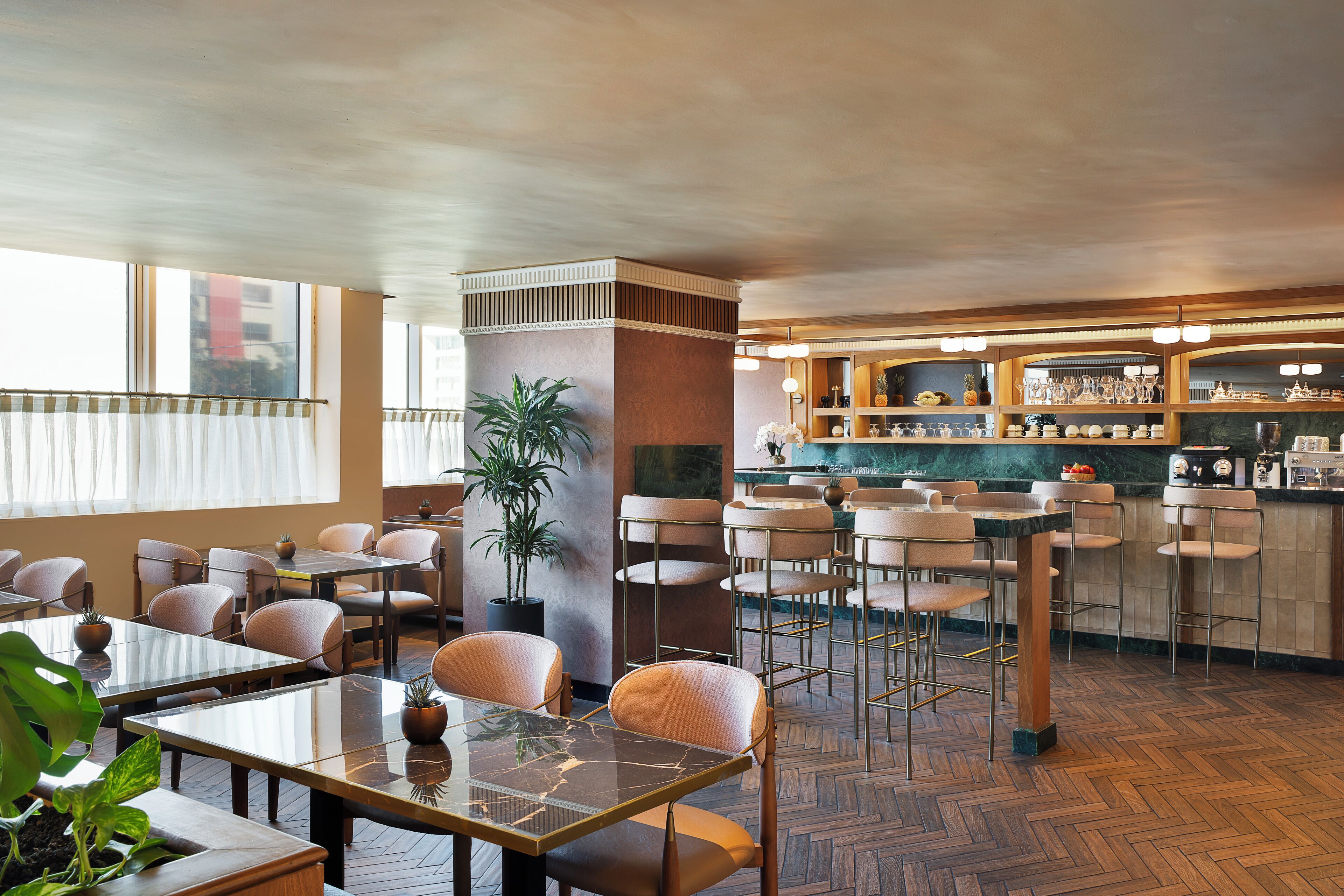 A restaurant with wooden flooring, bar area, and seating arrangements.