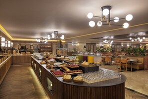 A buffet area with various food items and a seating area with tables and chairs. - DoubleTree by Hilton Casablanca City Centre (Casablanca)