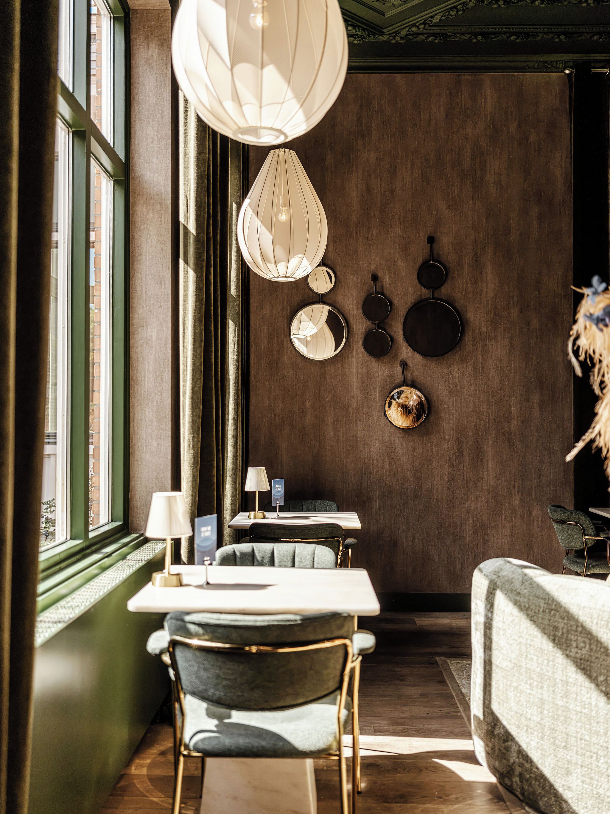 A dining area with a table, chairs, and a wall-mounted hanging light fixture.