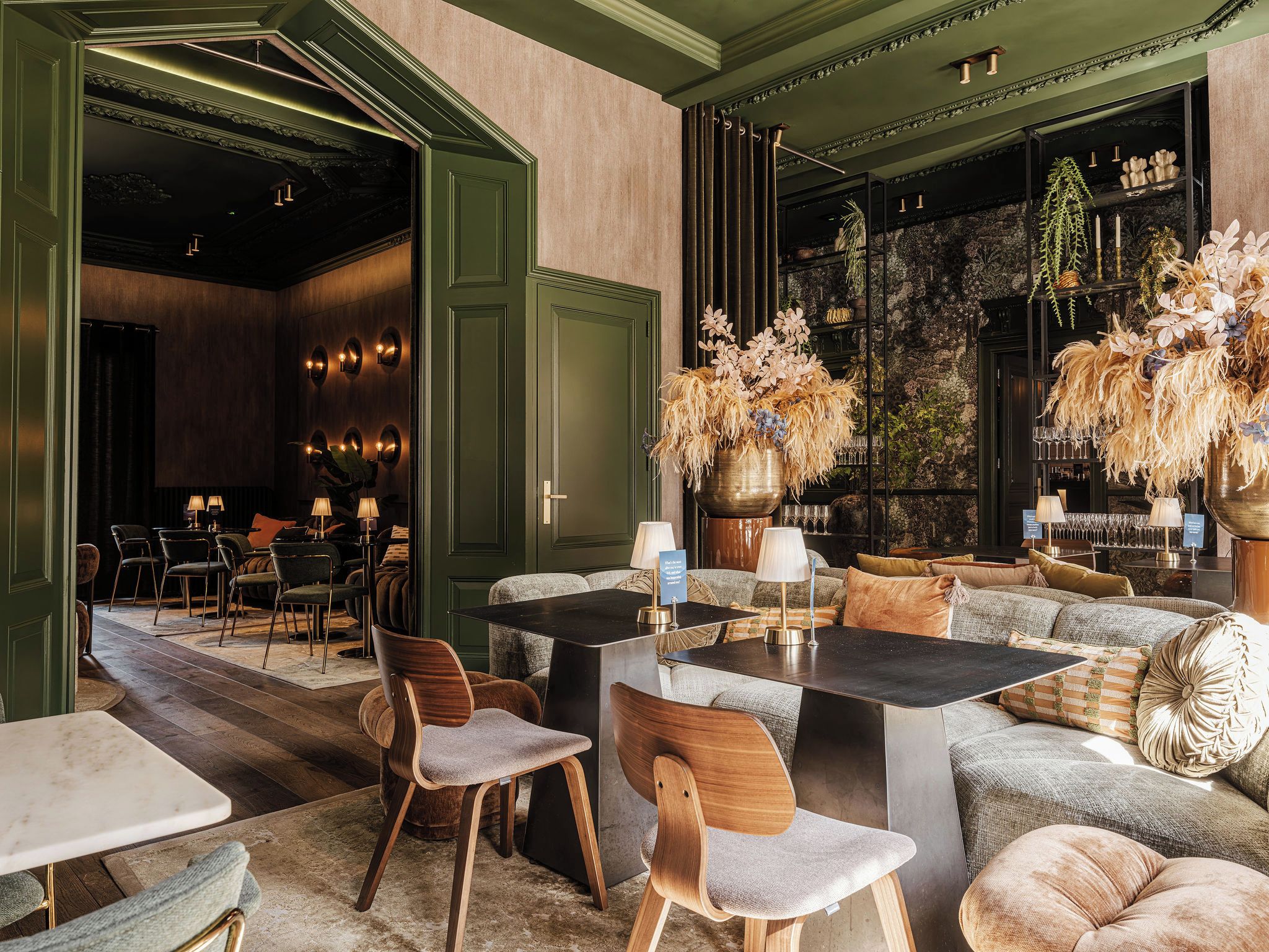 Un elegante área de estar con arreglos de asientos, una zona de bar y plantas decorativas.