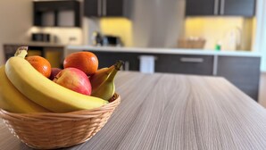 A wicker basket with fruits on a wooden table in a modern kitchen. - Court Residence (Linlithgow)