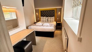 A compact hotel room with a bed, a small desk, and a window. - Court Residence (Linlithgow)