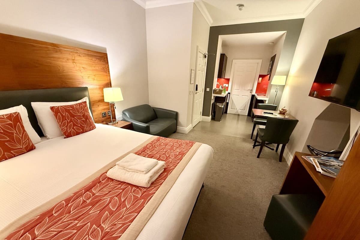 Une chambre d’hôtel équipée d’un lit, d’un bureau, d’une chaise et d’un téléviseur.