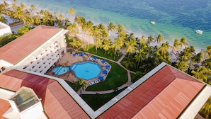 A resort with a large pool, palm trees, and a beach. - Mombasa Continental Resort (Mombasa)