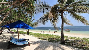 On the beach, white sand, sun-loungers, beach umbrellas