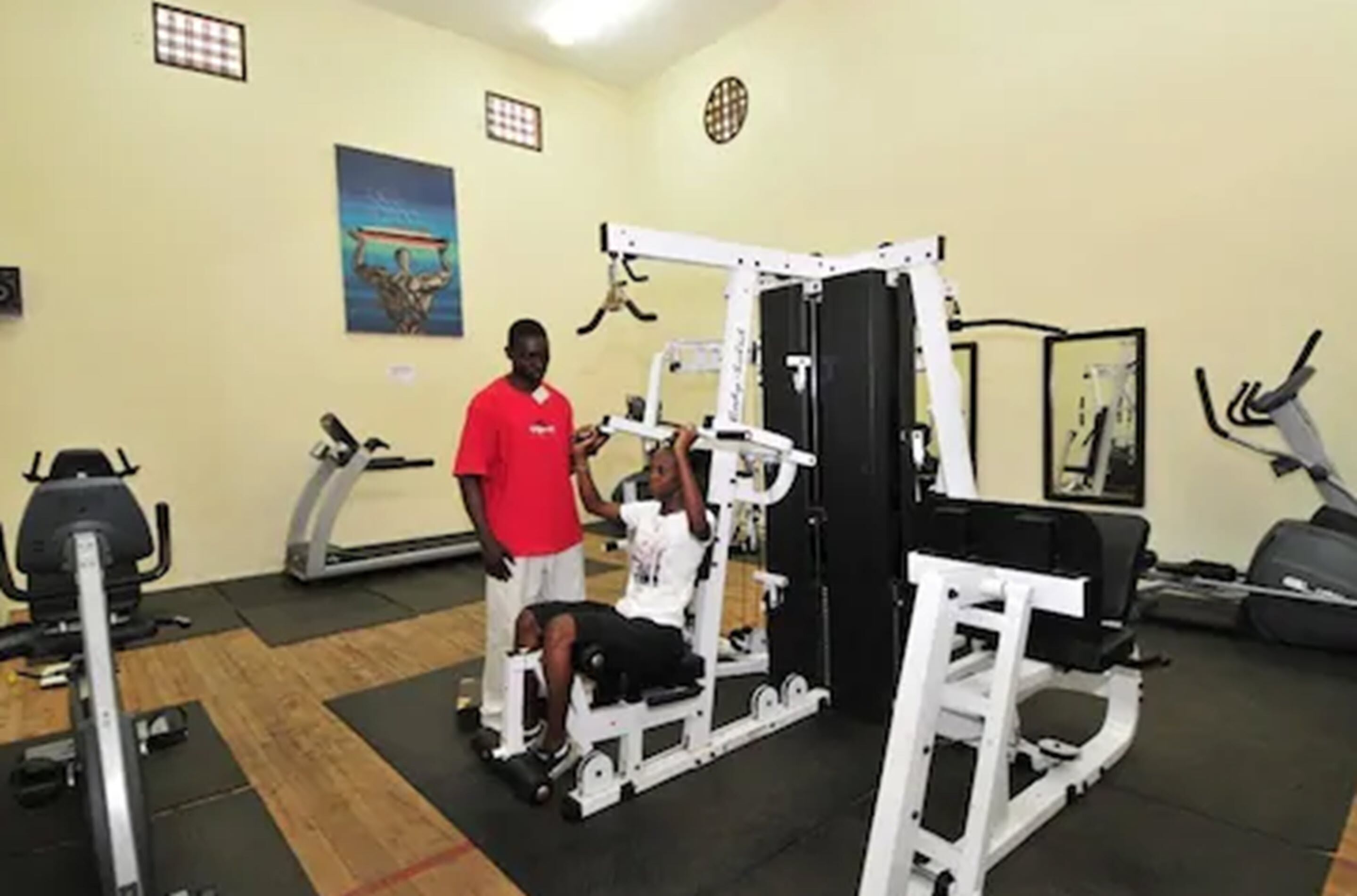 Ein Fitnessstudio mit verschiedenen Trainingsgeräten, darunter Laufbänder, Ergometer und Kraftgeräte.