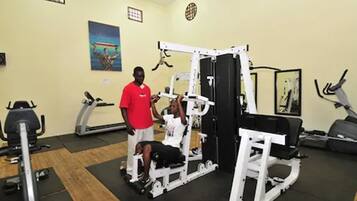 Ein Fitnessstudio mit verschiedenen Trainingsgeräten, darunter Laufbänder, Ergometer und Kraftgeräte.