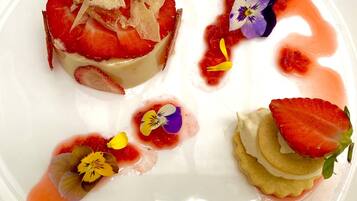Un plato de postre con diversas composiciones de fruta y decoración floral.
