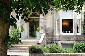 A stone building with a set of steps leading to a door, a sign indicating a 4-star rating, and a window with a light fixture.