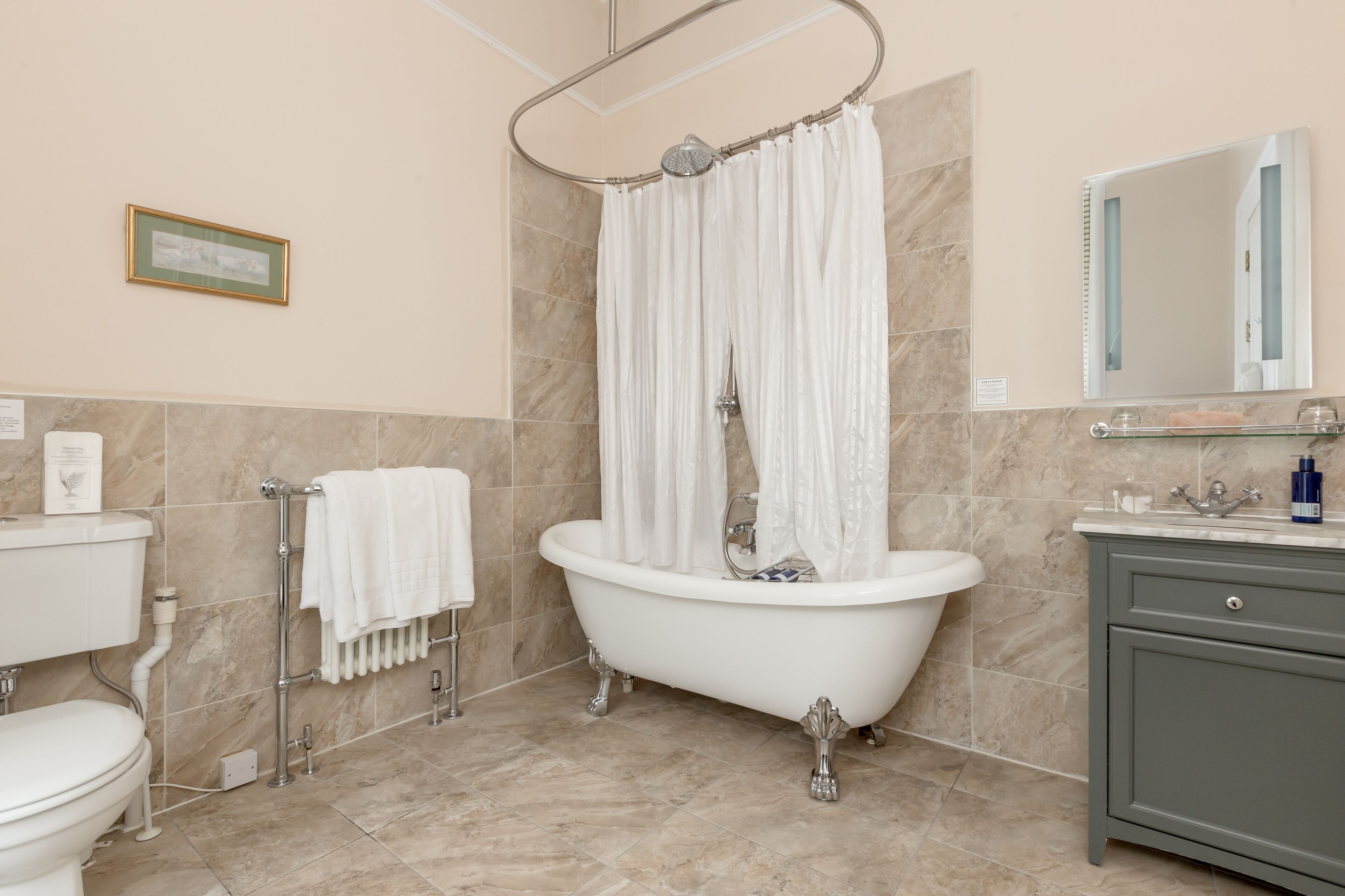 Un baño con bañera, inodoro, tocador y cortina de ducha.