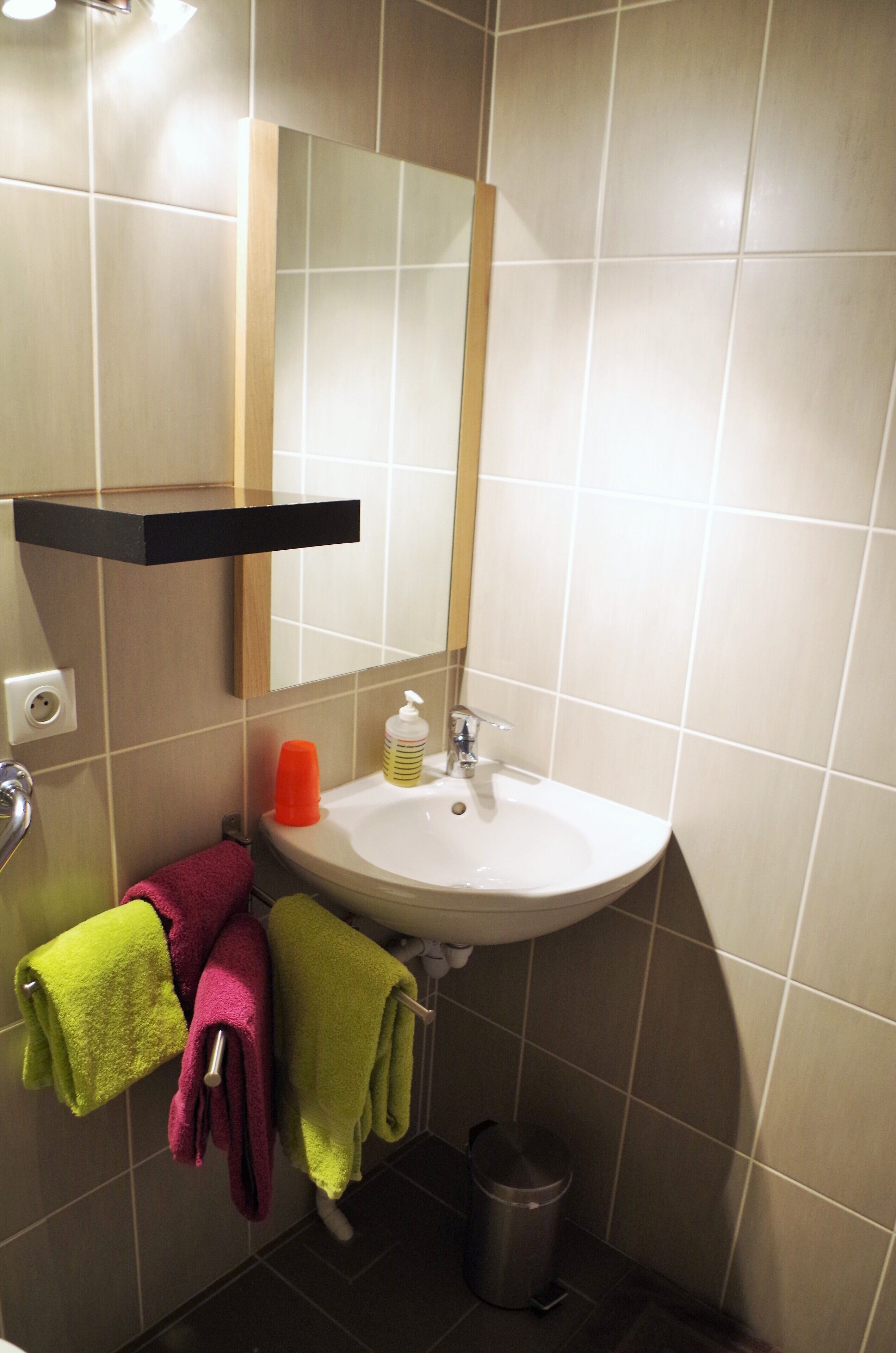 Un bagno con lavandino, specchio e portasciugamani.