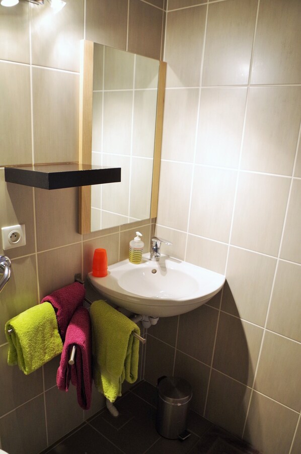 A bathroom with a sink, mirror, and towel rack.