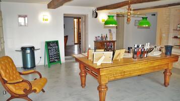 Een eetruimte met een houten tafel, een lederen stoel en een groene hanglamp.
