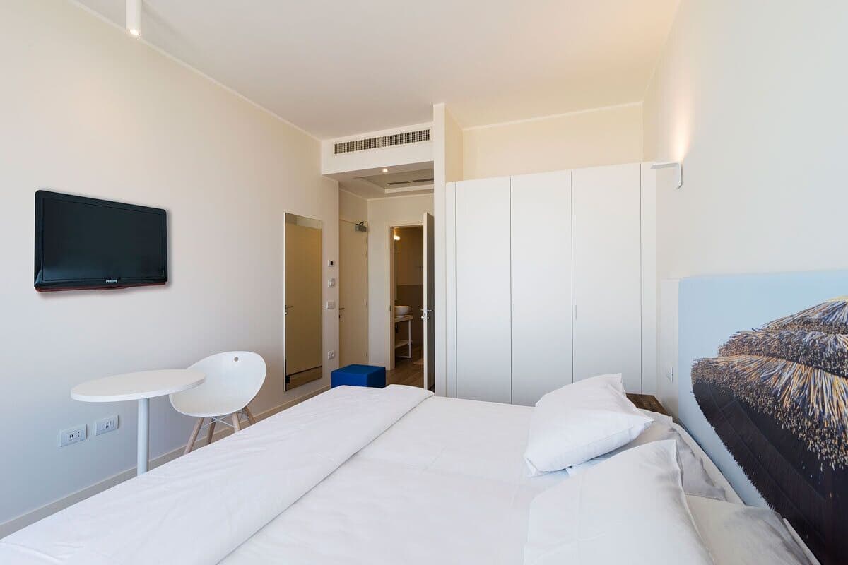 Une chambre d’hôtel équipée d’un lit, d’un bureau, d’une chaise et d’un téléviseur.