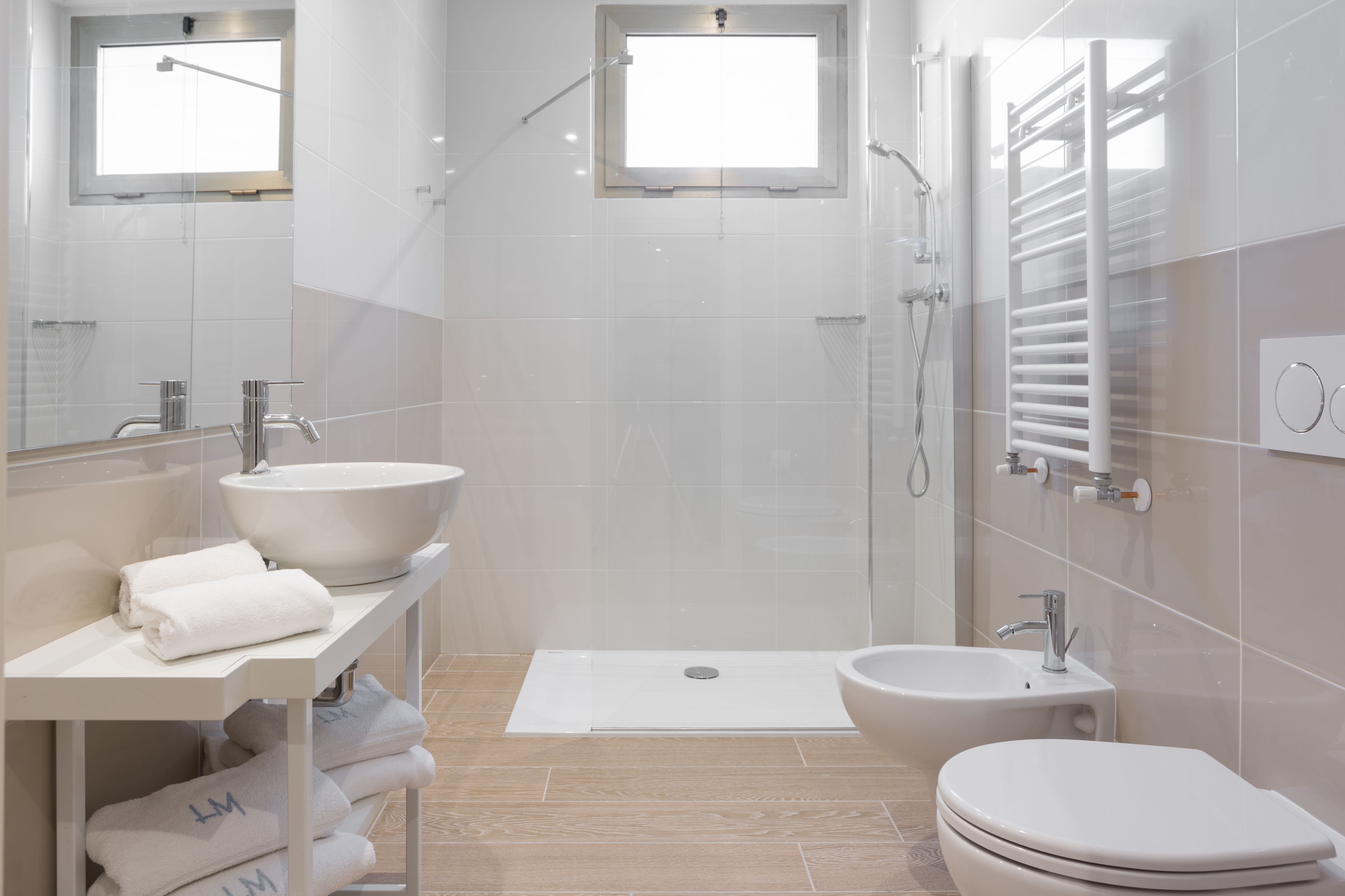 Un bagno moderno con un lavandino ampio, un bidet, un water e uno spazio doccia.