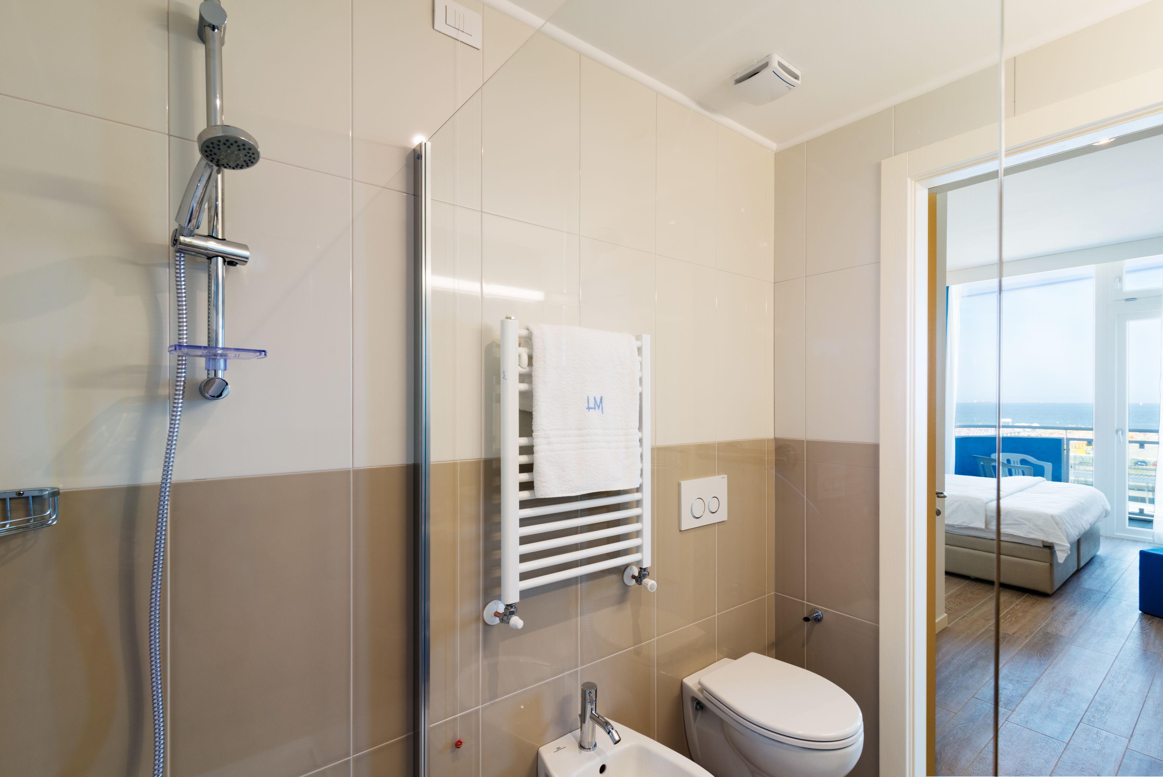 A modern bathroom with a shower, toilet, and sink.