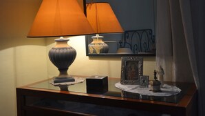 A table with a lamp, a framed picture, and decorative items. - La Rosa di Firenze (Florence)