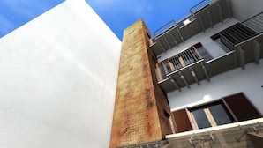 Un edificio moderno con una llamativa fachada de madera y un balcón con barandillas de metal.