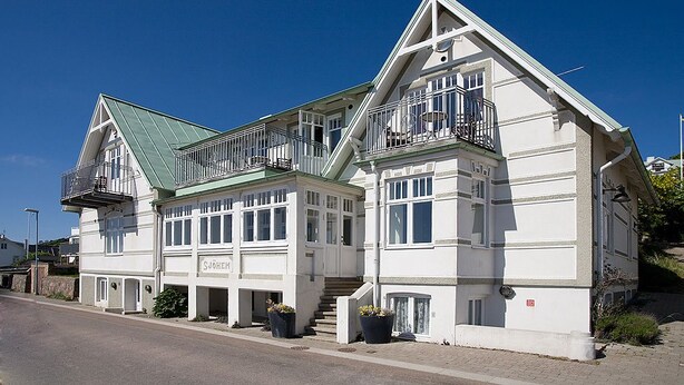 A two-story building with a green roof, white exterior, and multiple balconies. - Hotel Kullaberg (Molle)