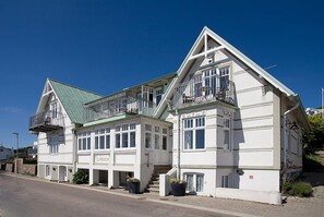 A two-story building with a green roof, white exterior, and multiple balconies. - Hotel Kullaberg (Molle)
