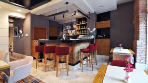 A modern bar area with a bar counter, stools, and a wine rack. - Hotel Wieniawski (Lublin)