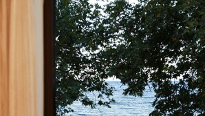 Vista desde una ventana sobre aguas abiertas, con una silla y una mesa a la vista en el interior.