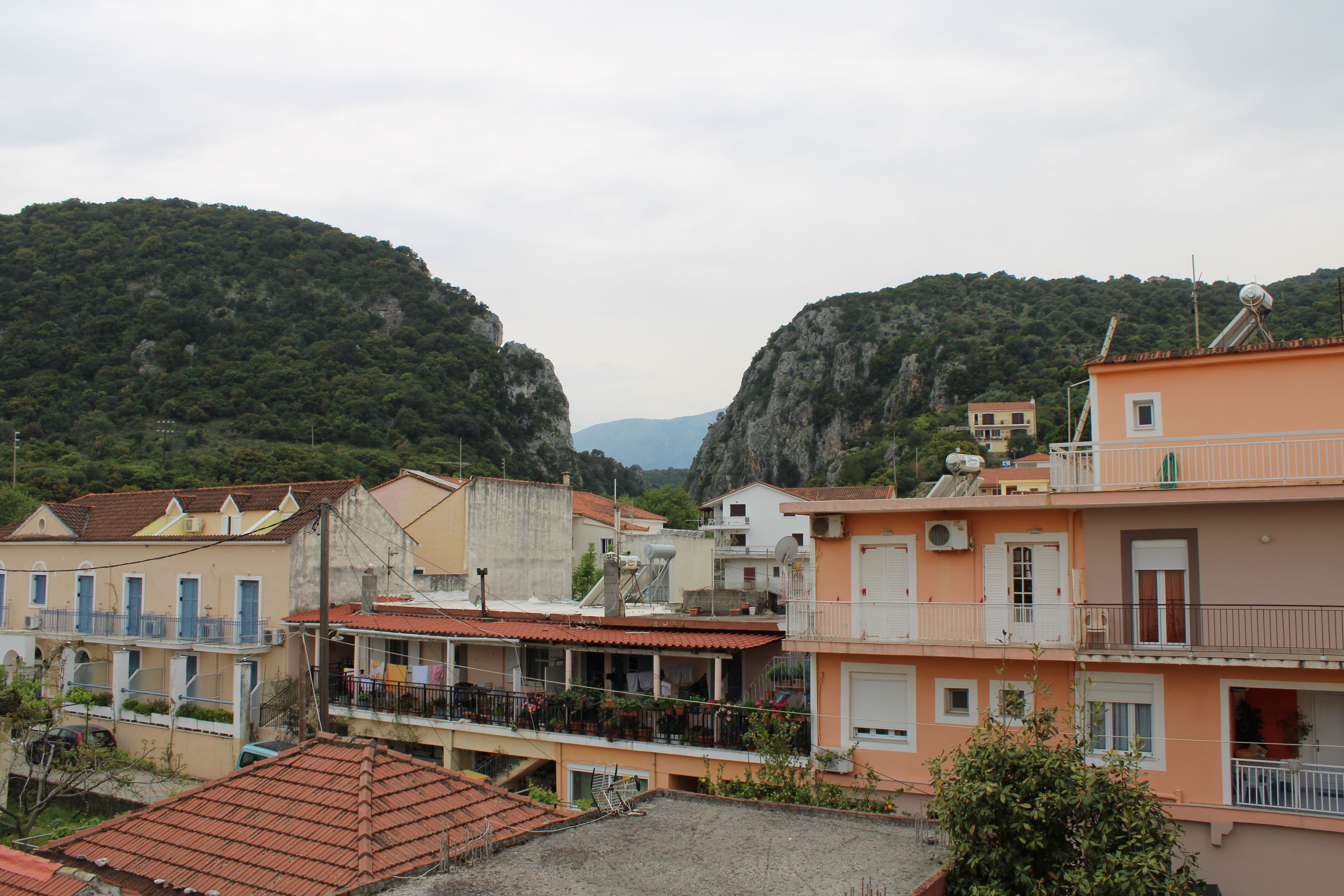Un pueblo costero con edificios que tienen balcones y techos de tejas rojas.