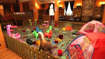 Zona de juegos infantiles con juguetes de colores y una carpa de Spider-Man.