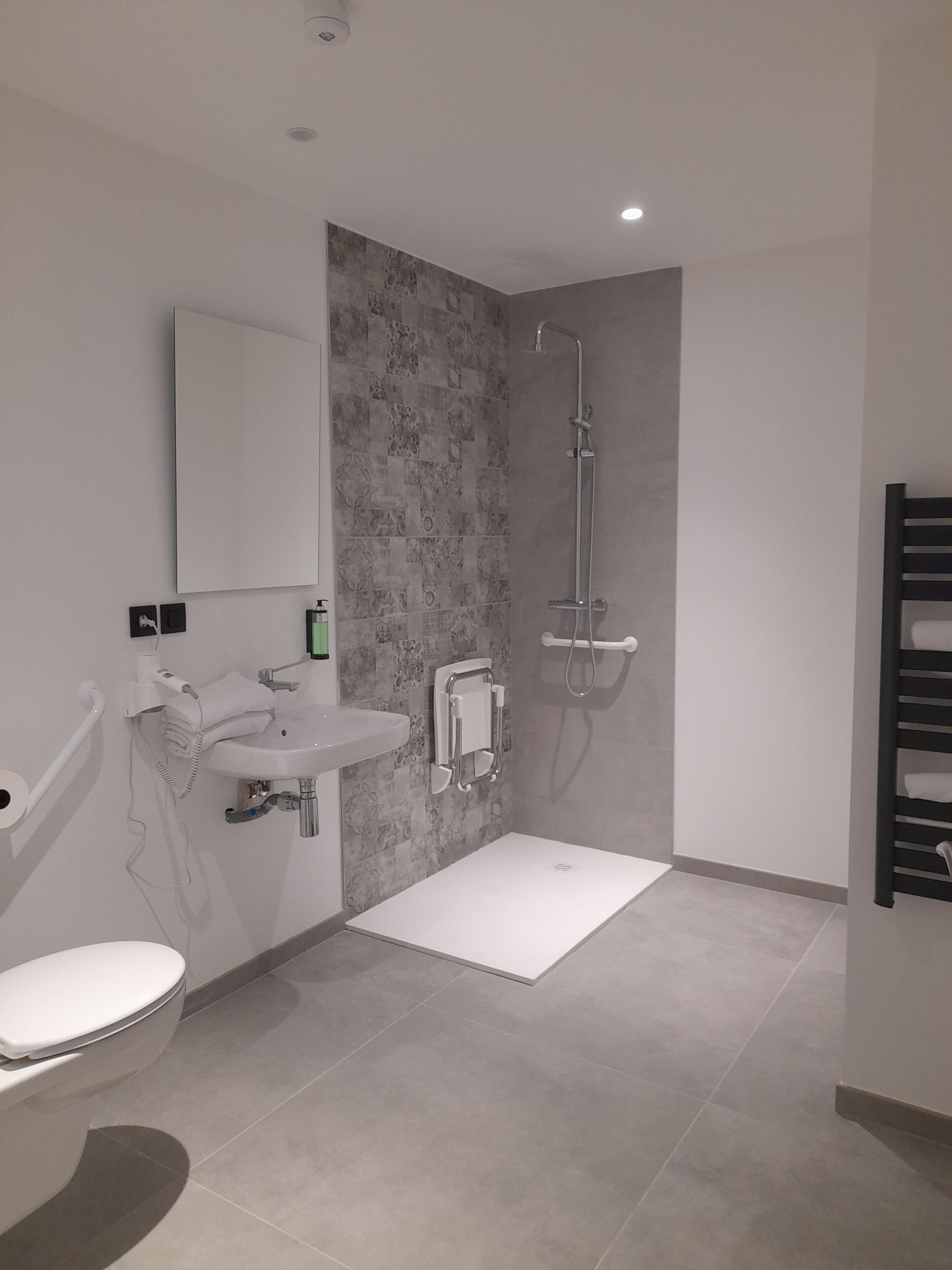 A modern bathroom with a toilet, sink, and shower.