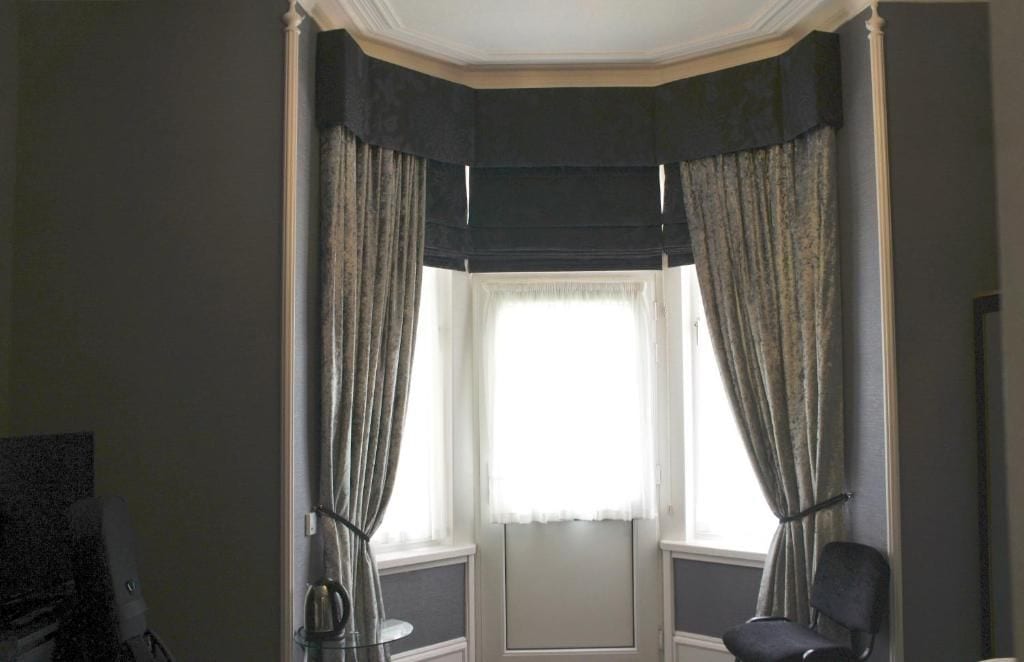 Una habitación con ventana, una silla y un escritorio.