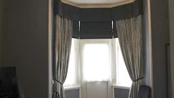 Una habitación con ventana, una silla y un escritorio.