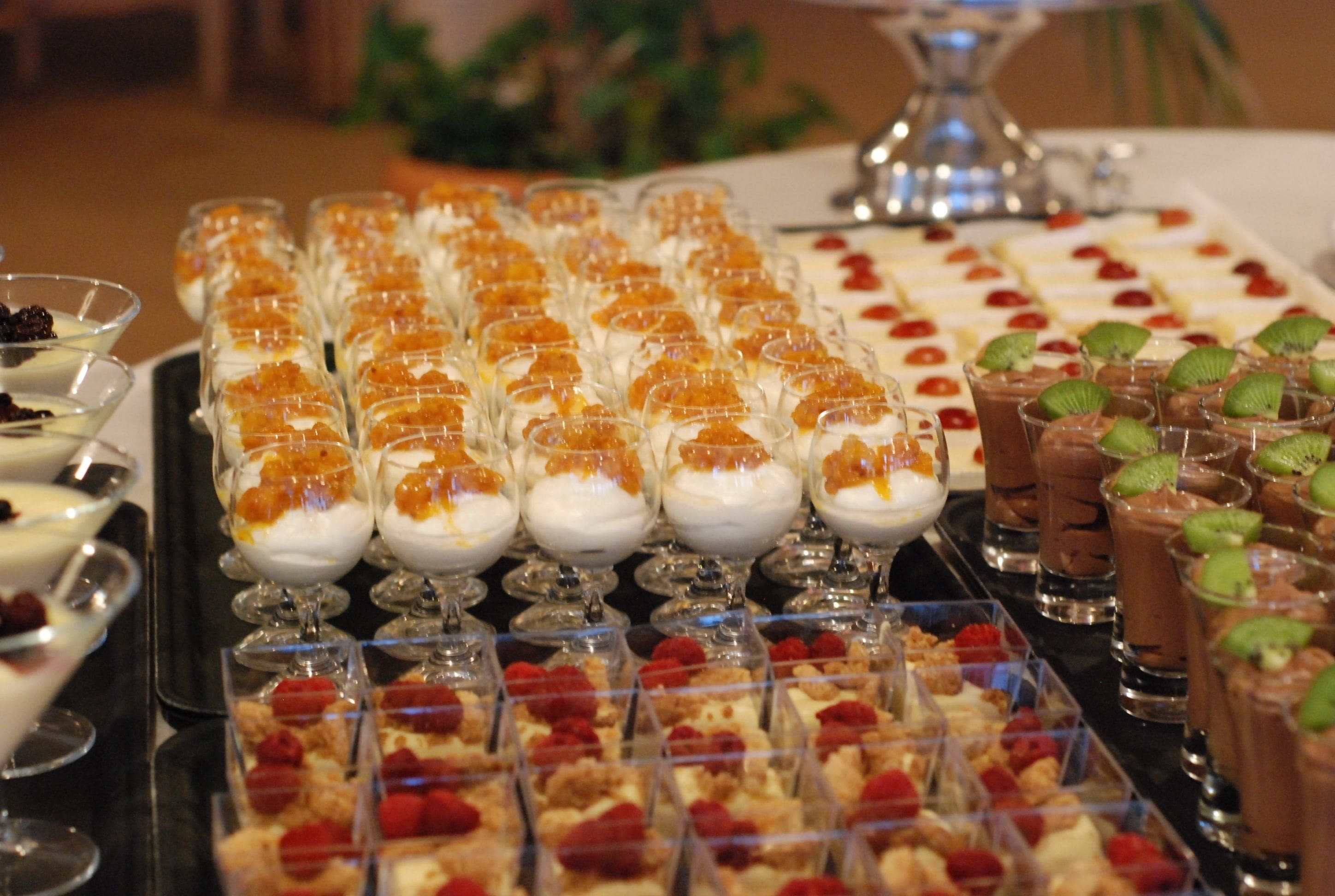A buffet with various desserts including parfaits, chocolate desserts, and fruit tarts.