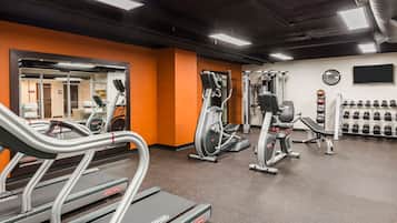 A gym with treadmills, elliptical machines, and weightlifting equipment.