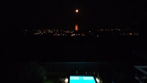A nighttime view of a swimming pool with a cityscape in the background. - Aurora dell'Etna (Zafferana Etnea)