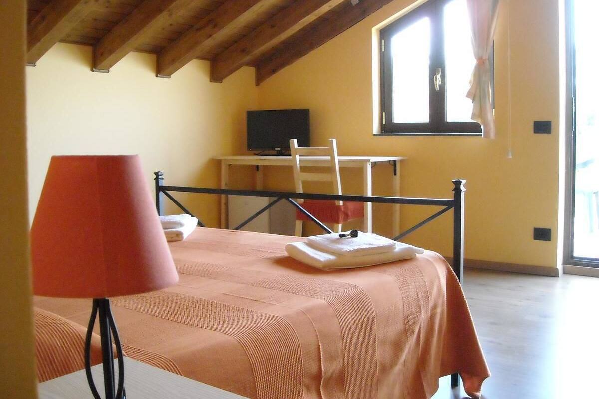 Un dormitorio con una cama, un escritorio y una silla.