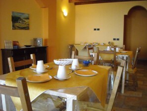 A dining area with tables set for four, each with white plates, bowls, and cups. - Aurora dell'Etna (Zafferana Etnea)